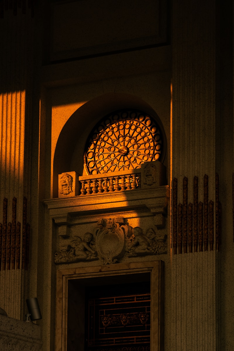 Ornate stained glass window illuminated by warm sunset light.
