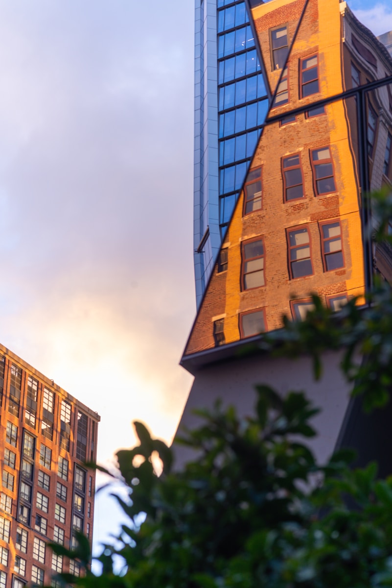 Modern and old buildings reflected at sunset